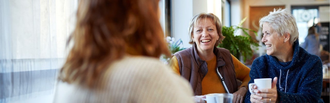 Group of woman inside cafe, laugh together.